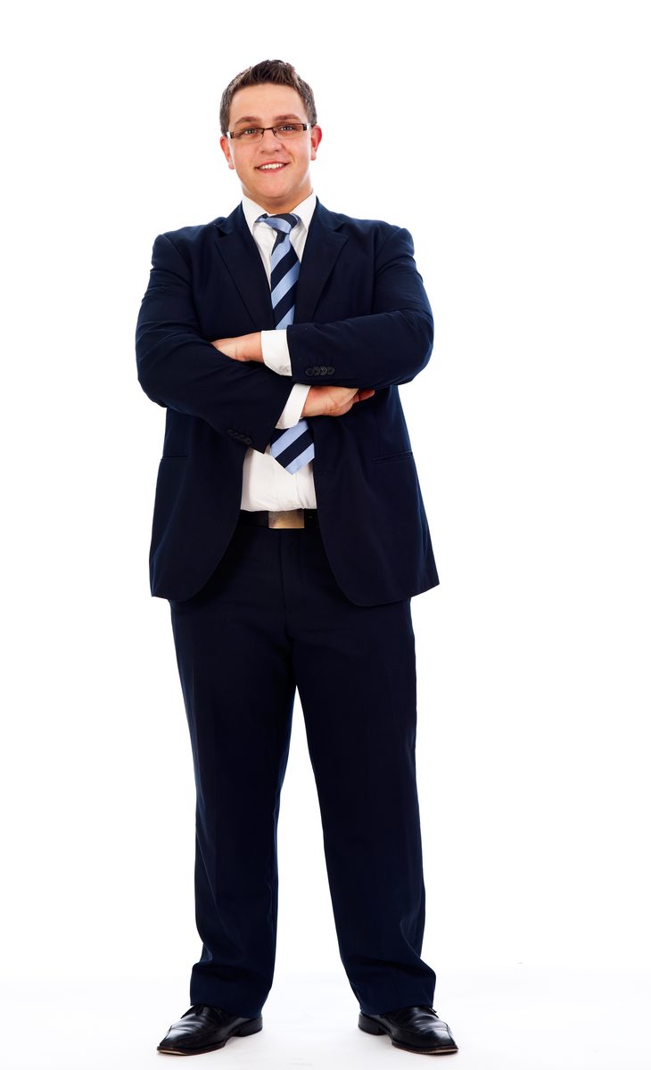 がっしりした体格で紺のスーツを着て立つ男性